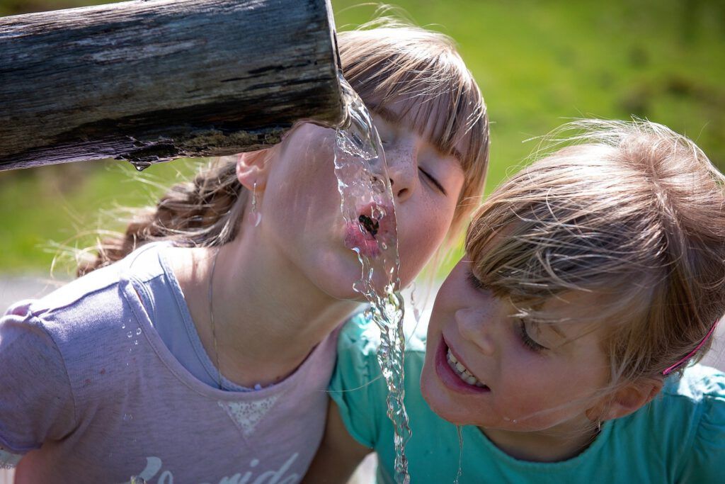 Niños y niñas bebiendo agua osmotizada